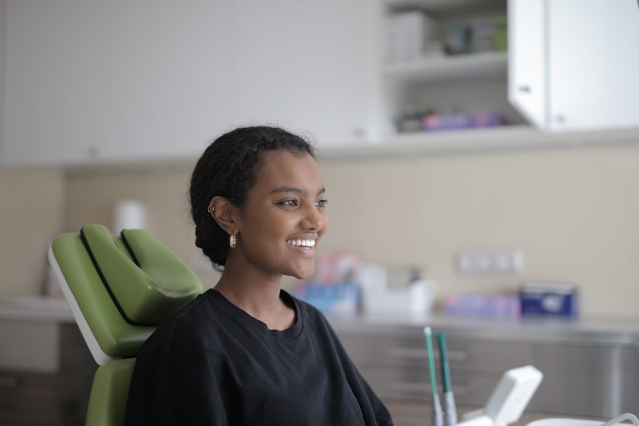 services-01 Young woman smiling in dental clinic chair, feeling relaxed and at ease.